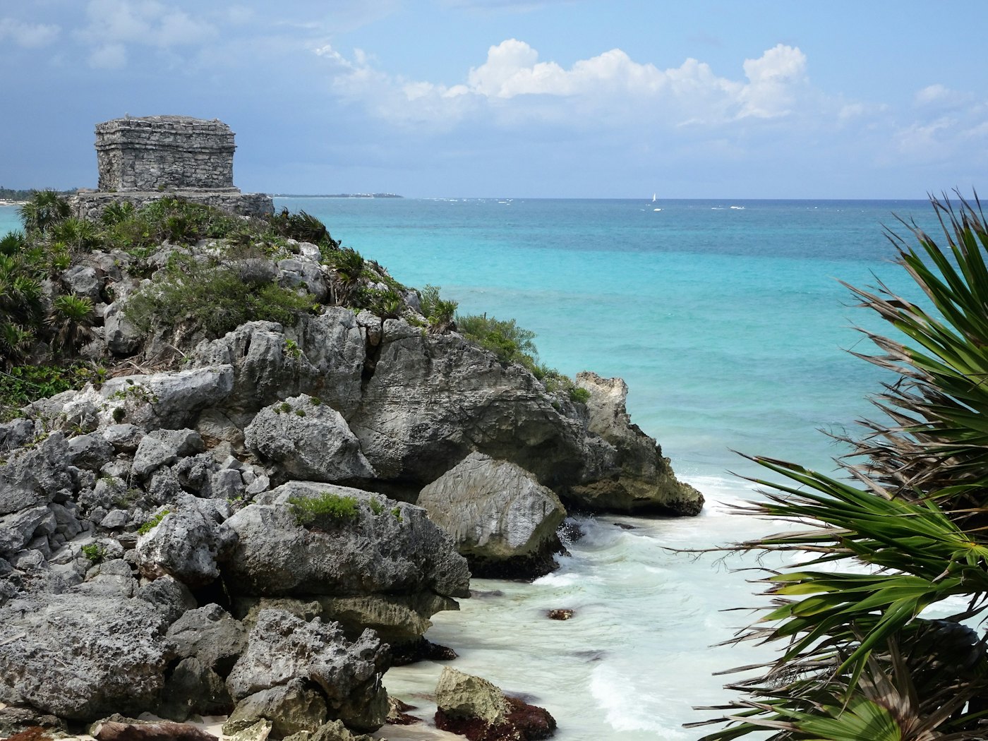 Mayan ruins on a limestone cliff above turquoise water at Tulum, Mexico